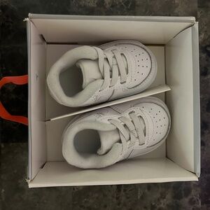 White Nike Air Force 1 crib shoes.